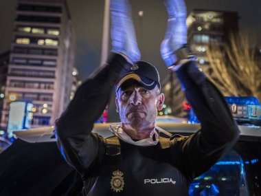 Bir Ulusal Polis memuru koronavirüsle mücadele eden sağlık personeline verdiği desteği alkışlıyor. Her gün saat 8 'de polis devriyeleri sağlık çalışanlarına saygılarını sunmak için Fundacion Jimenez Diaz hastanesinin önünde toplanıyor.
