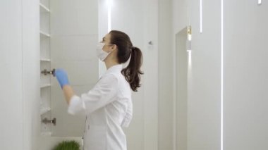 Maskeli kadın, karantina ve salgın sırasında yeni modern klinikte tıbbi belgeler arıyor
