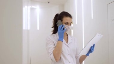 Doktor, yeni modern klinikte karantina sırasında hastanın teşhisini telefonda tartışıyor.