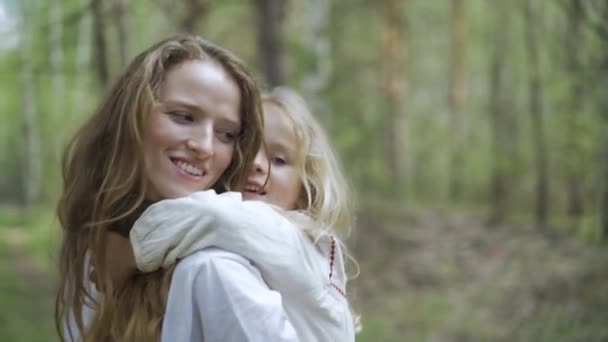 Klein blond kind meisje en haar jonge moeder spelen in het bos, familie wandeling — Stockvideo