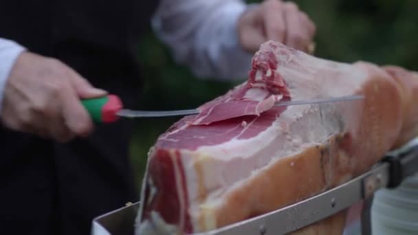 Человек Ножом Режет Испанский Хамон Подставке Ломтиками Кладет Красное Мясо — стоковое видео