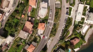 Güneşli bir yaz gününde Como Gölü 'nün en iyi manzarası. Evlerin, ağaçların, yolların ve onların yanından geçen arabaların güzel manzarası. Daire içinde İHA atışı