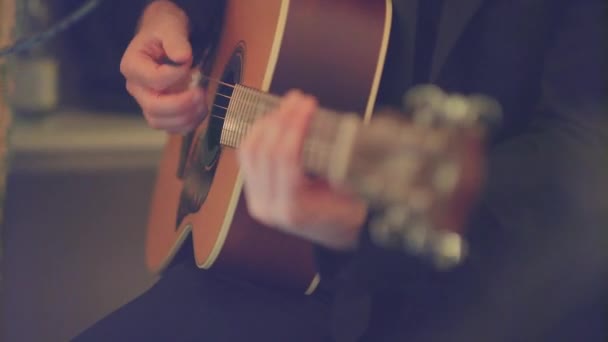 셔츠를 실내에서 조명을 이용해 노란색 어쿠스틱 기타를 연주하는 손에서 손으로 — 비디오