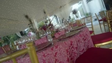 Üzerinde güzel tabaklar, çiçekler ve yaz günlerinde bardaklar olan kırmızı masa örtüsü olan bir şenlik masası. Düzüşme hareketi.