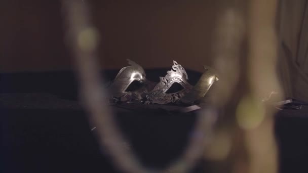 Маски Маскарада Золота Серебра Лежат Черном Столе Лучах Света Плавное — стоковое видео