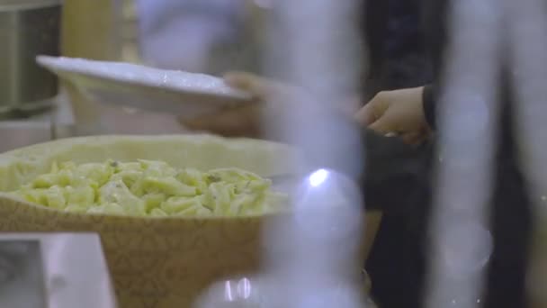 身穿黑衬衫的男人把意大利菜从奶酪的头上放进一个白盘里 — 图库视频影像
