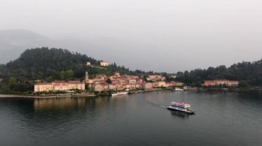 İtalya 'daki Como Gölü üzerindeki Lombardy' nin ünlü şehri Bellagio 'nun hava manzarası. Bulutlu bir yaz gününde su üzerinde giden bir gemi.