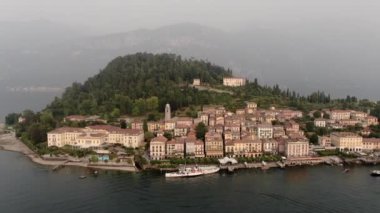 Hava aracı ile Bellagio, Lombardia City 'de Como Gölü' nde bir yaz günü gün batımında sisli bir dağın arka planına karşı video çekimi.