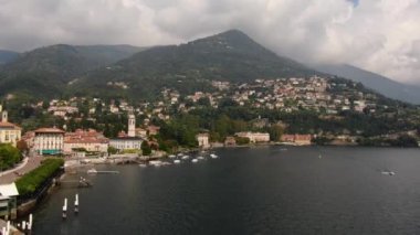 Cernobbio şehri, İtalya 'da Como Gölü üzerinde bulunan ve bulutlarla çevrili ünlü bir tatil beldesidir. Hava manzarası, yaz günbatımında bir drondan çekim.