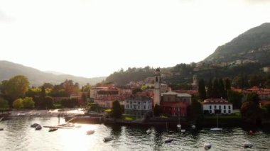 Cernobbio, İtalya 'da Como Gölü' nde popüler bir tatil beldesidir. Yazın gün batımının güzel hava manzarası. Yeşil dağların yamaçlarındaki güzel İtalyan evleri. İHA ateşi