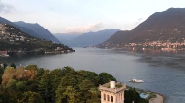 VERTIGO EFFECT (DOLLY ZOM veya eşzamanlı yaklaşım ve kaldırma). İtalya 'nın Cernobbio kentinin günbatımında Como Gölü' ndeki büyük dağlara karşı bir yaz günü hava manzarası. İHA ateşi
