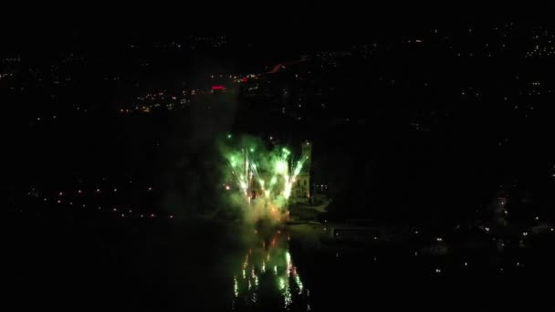 Feux d'artifice sur le lac de Côme à Cernobbio en Italie sur fond de ville nocturne. Des lumières salutaires colorées se reflètent dans l'eau. Vue aérienne, prise de vue par drone 