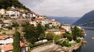 İtalya 'nın Laglio kentindeki Como Gölü kıyısında yer alan Villa Regina Teodolinda' dan panoramik bir manzara. Arabalar yol boyunca sürüyorlar. Güneşli bir yaz gününde İHA saldırısı