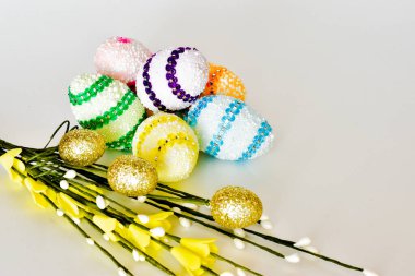 Easter colorful eggs with a pussy-willow twig on a white background