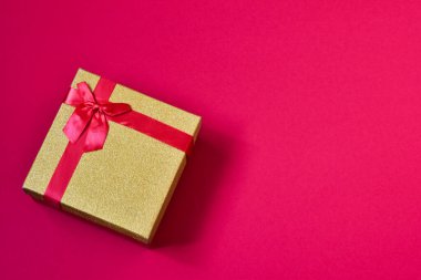 Parlak tatil kutusu. Kırmızı arka planda bir hediye. Tatil kavramı.