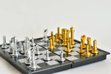 Beyaz arka planda satranç tahtasındaki altın ve gümüş satranç taşları. Şah mat. Kız, papaz, piyon.