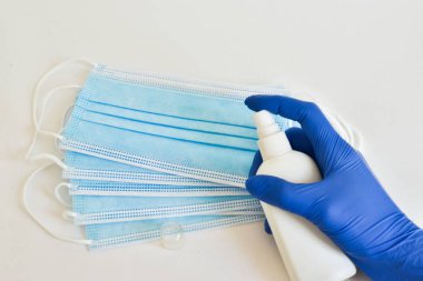 Küresel salgın COVID 19 'u durdurun. Koronavirüs cerrahi maskeleri ve koruma için dezenfekte jeli, el hijyeni. Antiviral, solunum bandajı mavi arka planda..