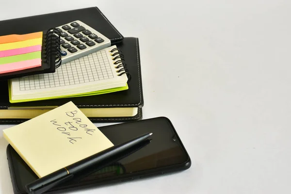 Back to work, written on a piece of paper. On a white background diary, calculator, paper, notebooks. Place for text.