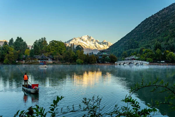 Göl manzarayı ve kar dağını yansıtıyor. 