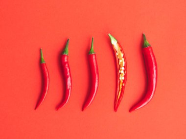 Kırmızı arka planda taze kırmızı biber. Düzleştirme biçimi.