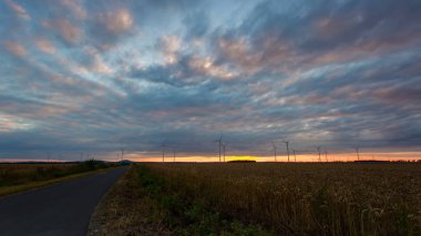 Yel değirmeni çiftliğinin arkasında gün batımı. Geniş açı