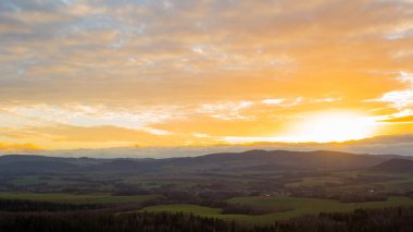 Güzel altokümülüs bulutları gün batımında Polonya 'nın huzurlu dağ köyü üzerinde yuvarlanıyor.