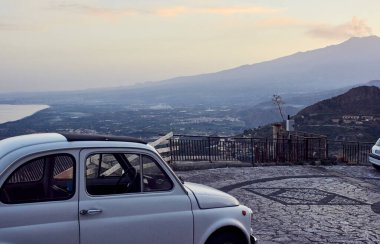 Etna Dağı perspektifine park edilmiş klasik bir araba.