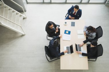 Asyalı iş adamlarının istatistik analizi takımının en üst görüşü. İş adamlarından oluşan bir ekibin yüksek açılı görüşü Toplantı Konferansı Kurumu Konsepti ofiste.