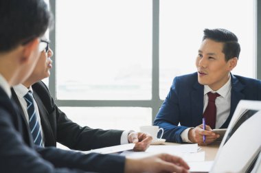 Asyalı iş adamları istatistikleri analiz ediyor. İş Adamları Ekibi Konferans Kurumsal Kavram Toplantısı Ofiste.