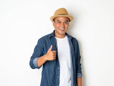 30 yaşlarında Asyalı erkekler şapka ve kot pantolon giyip başparmak gösteriyorlar..