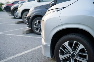 Birçok araba büyük bir otoparka park edilmiştir. Uzun bir sıra halinde dizilmişti güneşin battığı zamandı