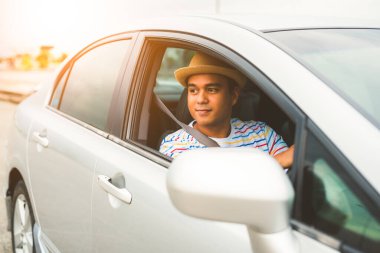 Arabayla seyahat eden yakışıklı Asyalı genç adam..