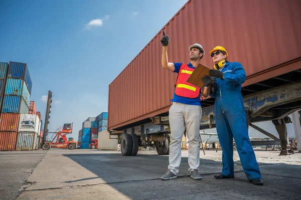 Foreman and dock worker staff working checking at Container cargo harbor holding clipboard. Business Logistics import export shipping concept.