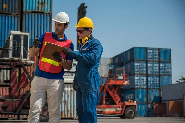 クリップボードを保持コンテナ貨物港でチェック作業フォアマンとドックの労働者のスタッフ ビジネス物流輸出入輸送コンセプト — ストック写真