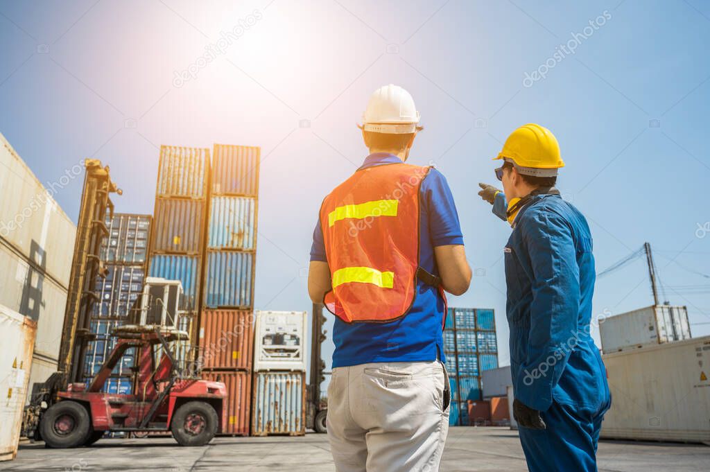 Foreman and dock worker staff pointing the finger and working at Container cargo harbor. Business Logistics import export shipping concept.