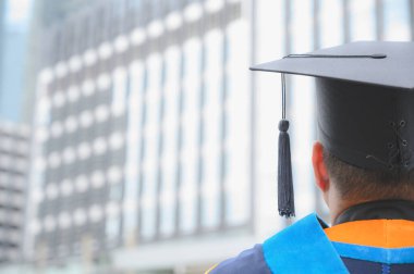 Mezunların arka görünüşü üniversitedeki mezuniyet törenine katılıyor.