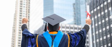 Mutlu mezun. Mezuniyet elbiseli mutlu Asain adam şehir geçmişi üzerine diplomasını elinde tutuyor..