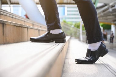 Metropolis Finans 'a, başvuru formuna arka planı olan iş adamları merdivenlerden yukarı çıkıyor.