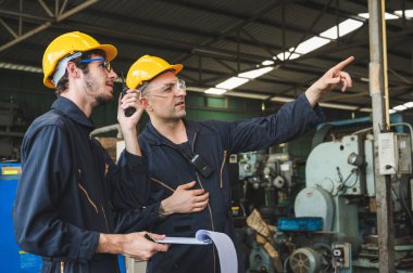 Endüstriyel işçiler büyük sanayi tesislerinde pek çok cihazlı projeler üzerinde çalışıyorlar..