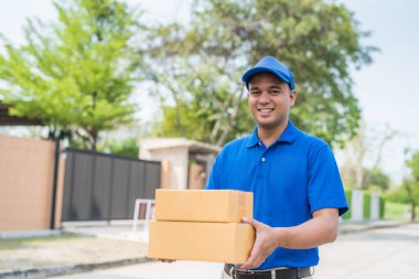 Mavi üniformalı ve karton kutulu adamı teslim et.