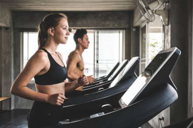 Genç çift her zaman sağlıklı kalmak için koşu bandında koşuyor.