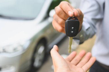 İş adamı araba anahtarı veriyor. Yeni araba konsepti.