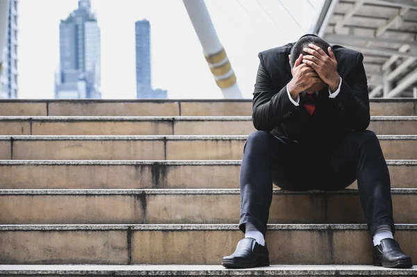 Business people are stressed, put their hands on the head about unemployment, stress, work hard, have a big city backdrop