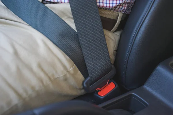 Man putting on his seat belt in his car. Safety drive concept.