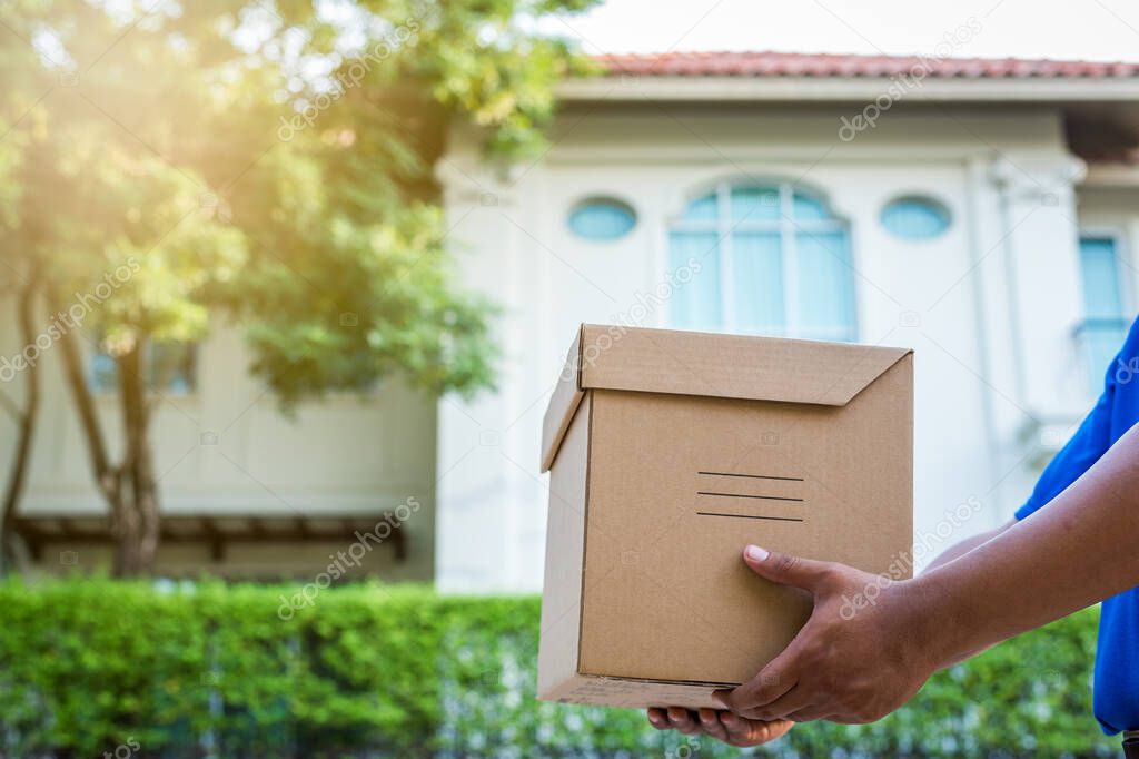 Blue Delivery man holding parcel cardboard box.