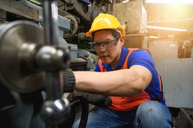 Asyalı endüstriyel işçiler büyük sanayi tesislerinde pek çok cihazlı projeler üzerinde çalışıyorlar.