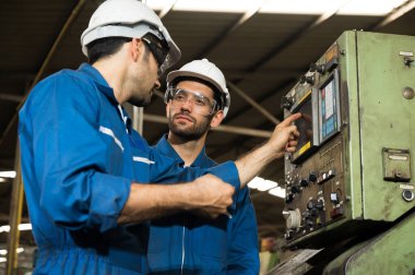 Endüstriyel işçiler büyük sanayi tesislerinde pek çok cihazlı projeler üzerinde çalışıyorlar..