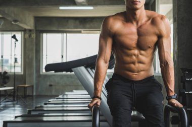 Beden eğitiminde güçlü kaslı adam pazularda egzersiz yapıyor. Ağırlık antrenmanı konsepti.