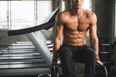 Beden eğitiminde güçlü kaslı adam pazularda egzersiz yapıyor. Ağırlık antrenmanı konsepti.