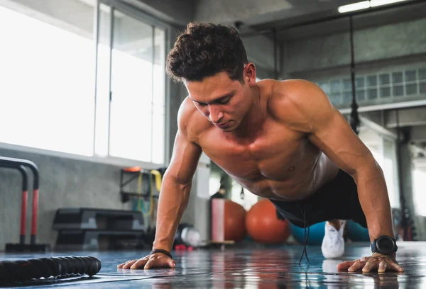 Fitness adamı jimnastik salonunda şınav çekiyor. Egzersiz ve egzersiz konsepti.